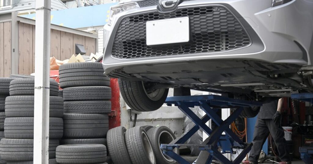リフトアップされた車と積み上げられたタイヤ