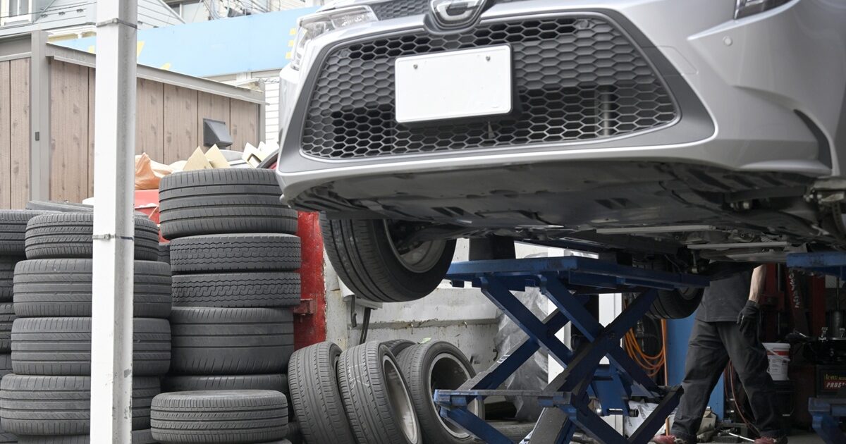 リフトアップされた車と積み上げられたタイヤ