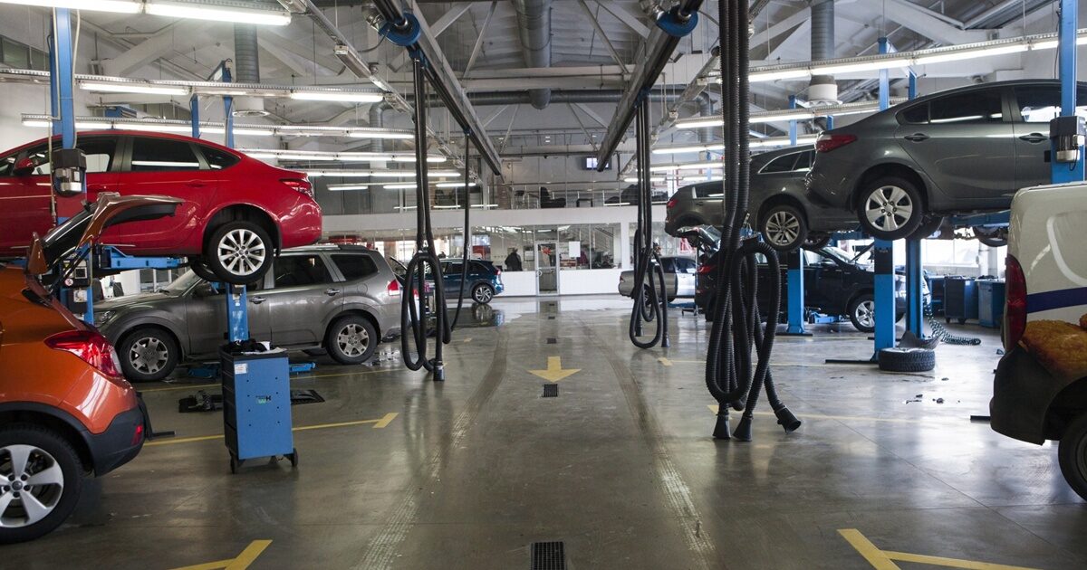 複数の車両がリフトで上げられて整備中の自動車整備工場の内部
