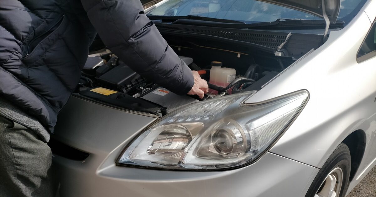 車のボンネットを開けて点検する男性