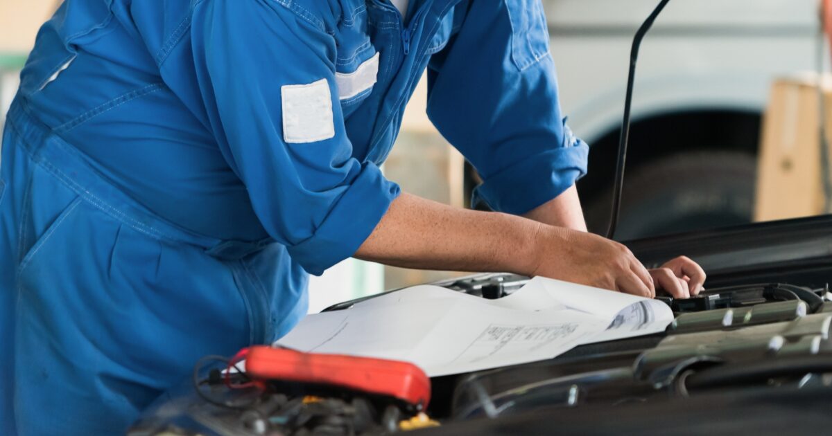 配線図を確認しながら整備する自動車整備士