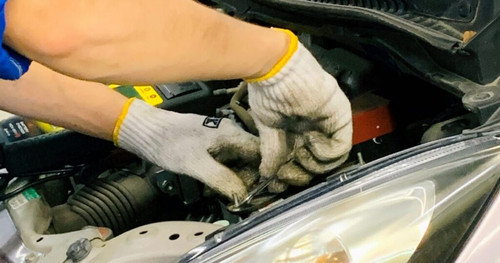 エンジンルーム内で整備作業を行う整備士の手元