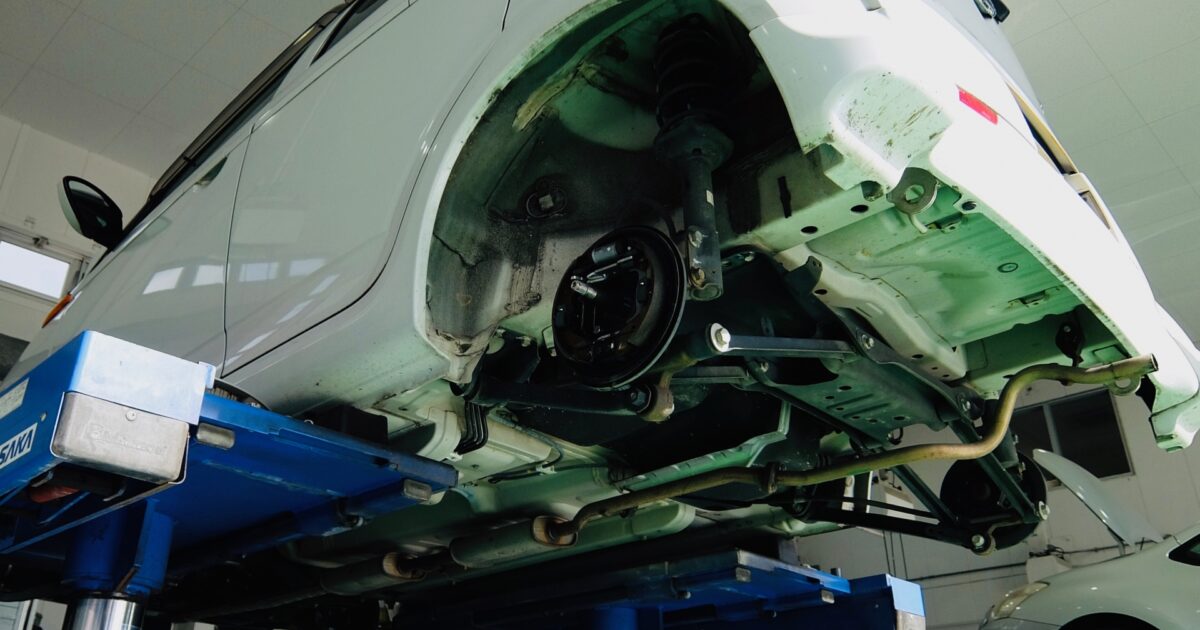 整備工場でリフトアップされた車両の足回り