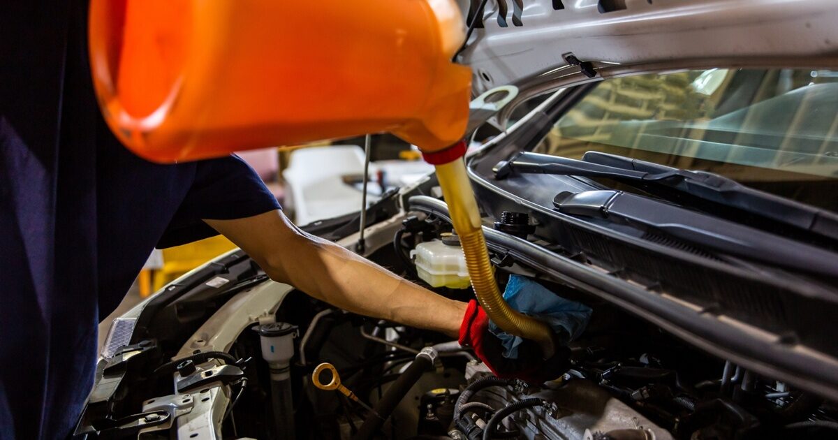 エンジンにオイルを注入する整備士の作業風景