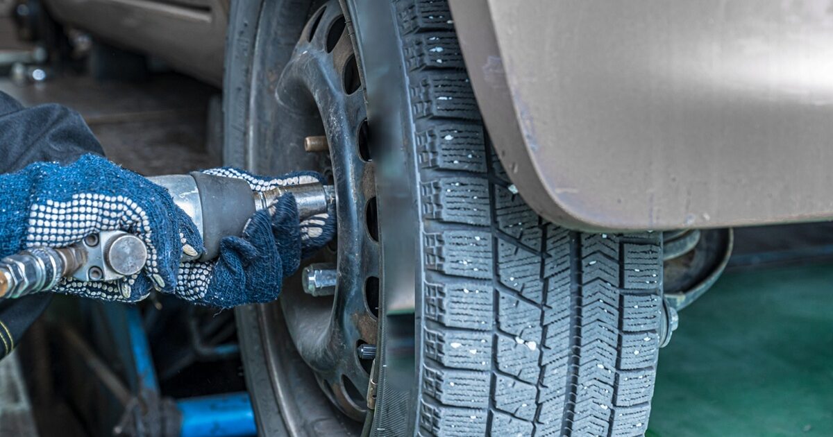 インパクトレンチでホイールナットを締める整備士の手元
