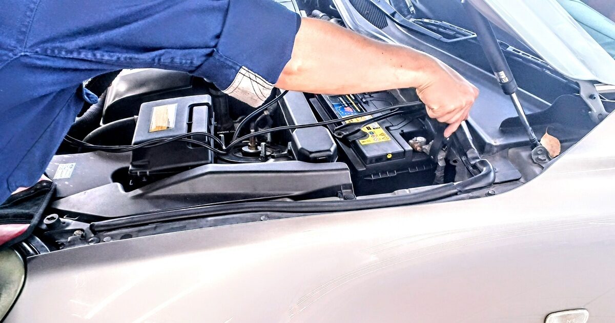 自動車バッテリーを点検する整備士の手元